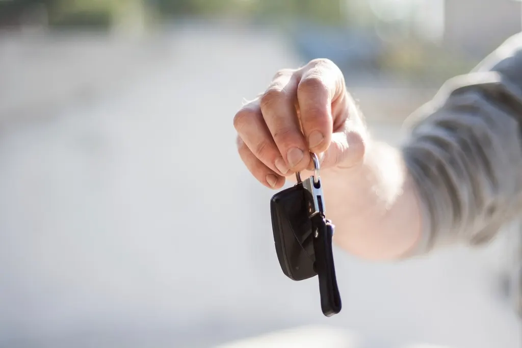 Iemand geeft een autosleutel over